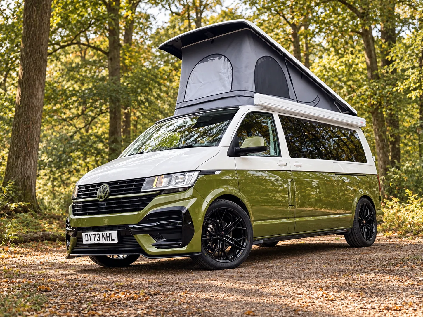 Vanlord campervan with its pop-top raised in a woodland clearing