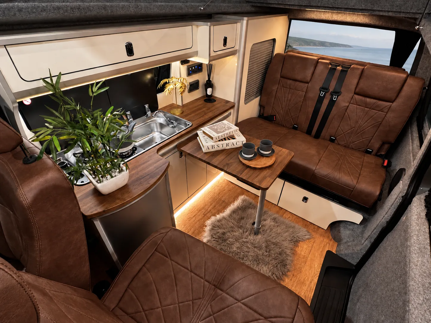 Vanlord camper interior with a seaside view through the rear window