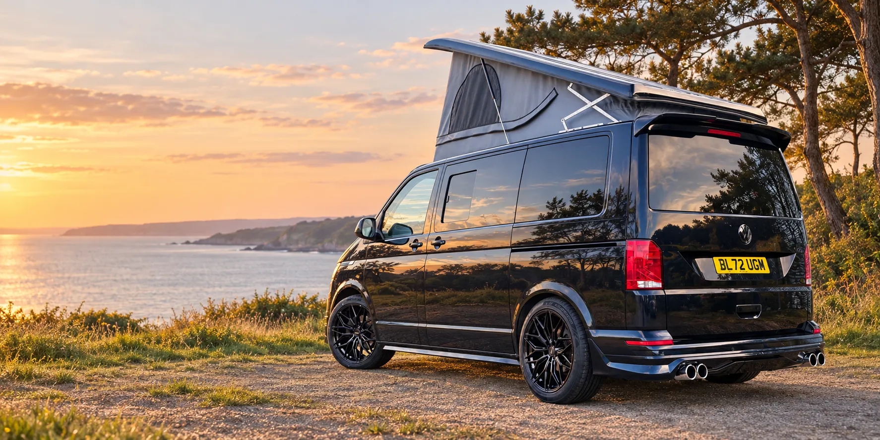 Black Vanlord campervan parked beside the coast at sunset